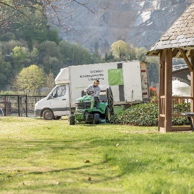 Entretien de pelouse avec une tondeuse dans un jardin à Andenne