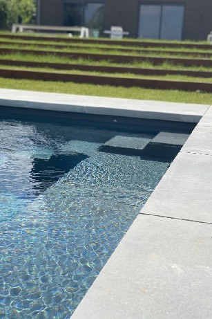 Aménagement d'une piscine avec pose de mégadalles Grey velvet et bordures en acier corten à Ohey